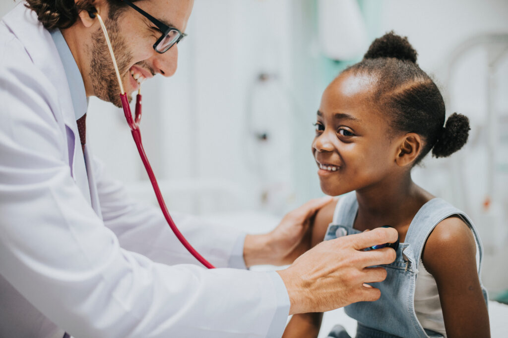 Friendly pediatrician checking a little girls heart.
